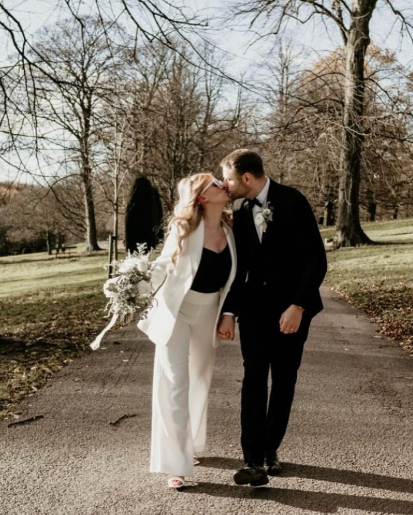 Bride and groom in made-to-measure wedding attire by Alex Laine, sharing a kiss on their special day.